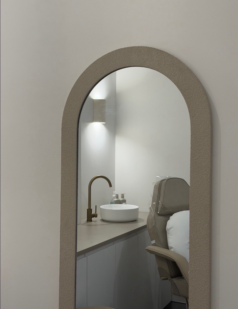 An arched mirror and considered interior details in the clinic.