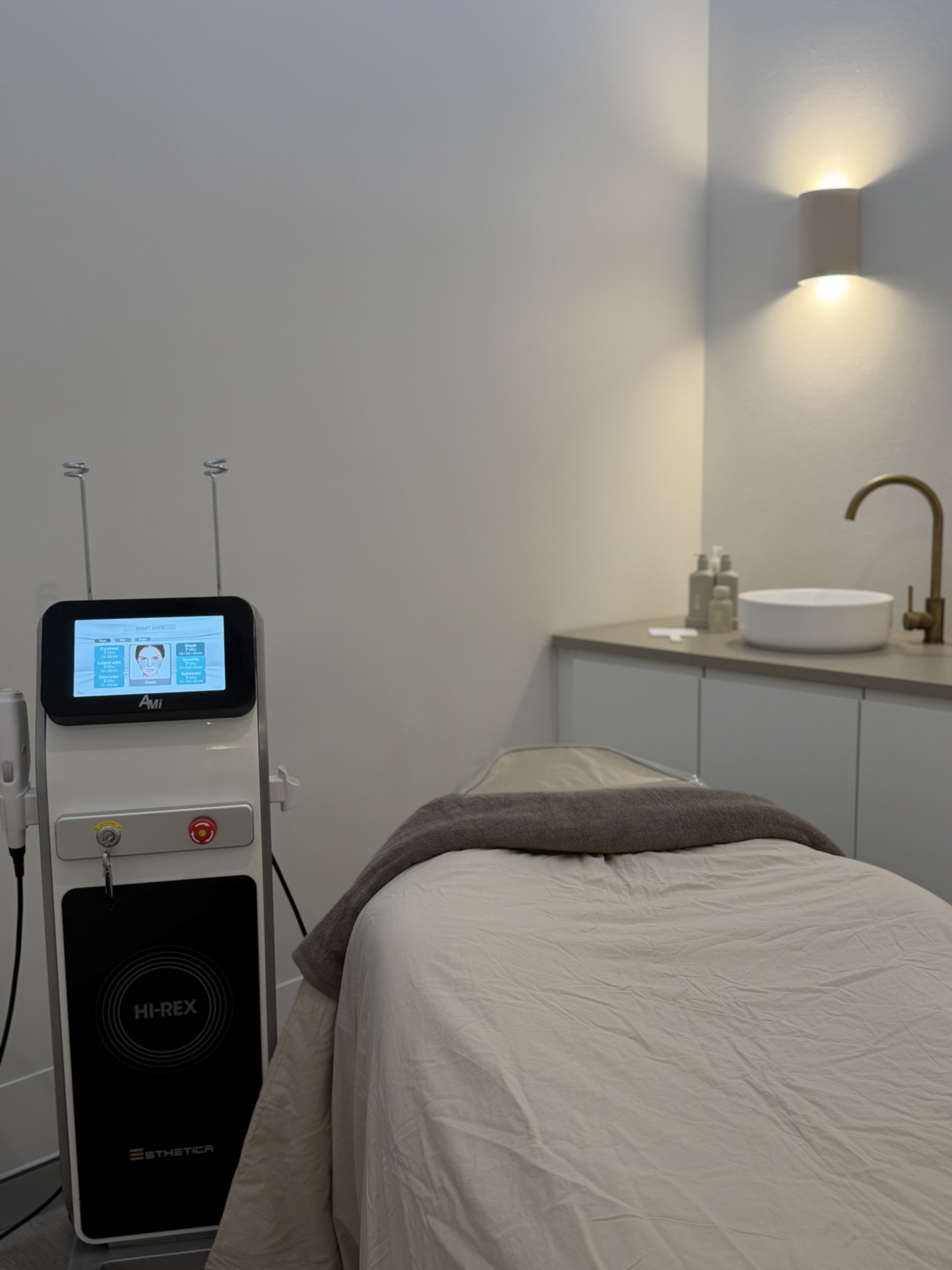 The HI-REX system beside a treatment bed in a softly lit clinic room.